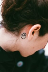Close-up of a small tattoo behind a person's ear. Shot in São Paulo.