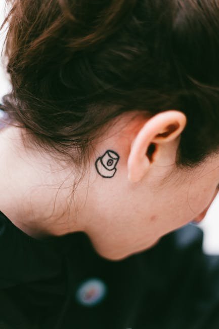 Close-up of a small tattoo behind a person's ear. Shot in São Paulo.